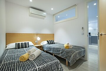 A bedroom with two twin beds and a window
