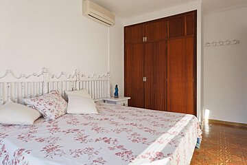 A bedroom with a floral bedspread and pillows