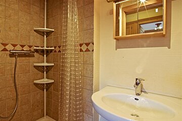 A bathroom with a clear shower curtain and a sink