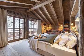 A bedroom with a tray of food on the bed
