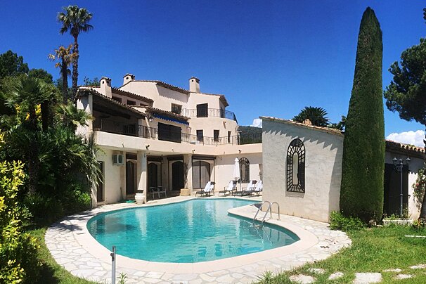 A large house with a large swimming pool in front of it