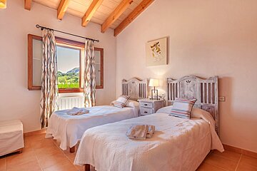 A bedroom with two twin beds and a window