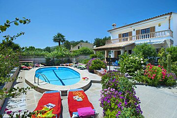 A large house with a swimming pool in front of it