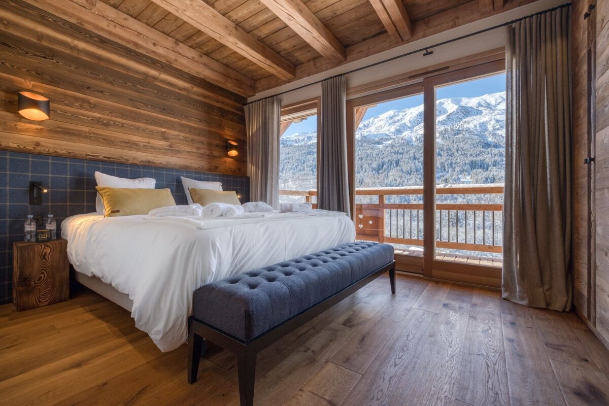 A bedroom with a large bed and a bench