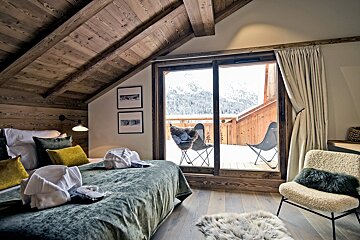 A bedroom with a sliding glass door leading to a balcony