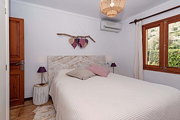 A bedroom with a white bed and a wooden headboard