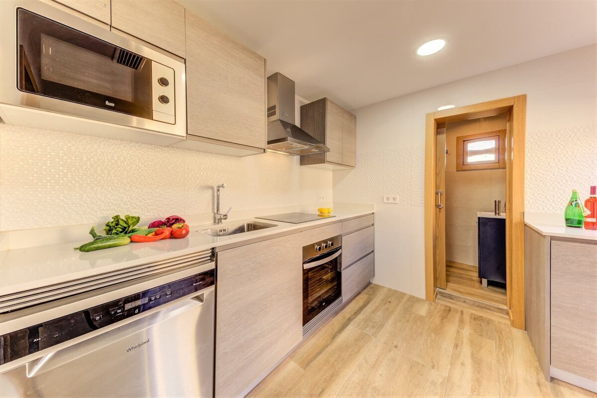 A kitchen with a stainless steel dishwasher and a stainless steel microwave