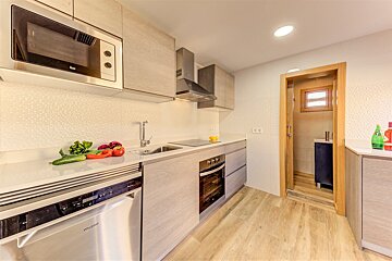 A kitchen with a stainless steel dishwasher and a stainless steel microwave
