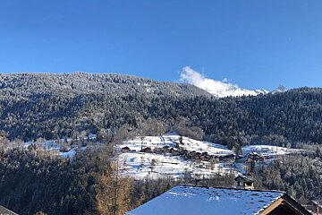 A snowy mountain with a small village in the foreground