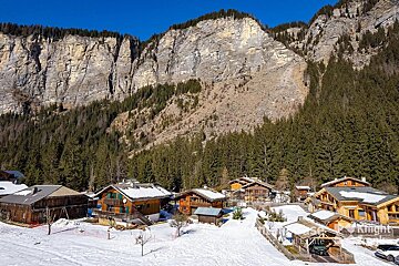 An aerial view of a snowy village with a mountain in the background