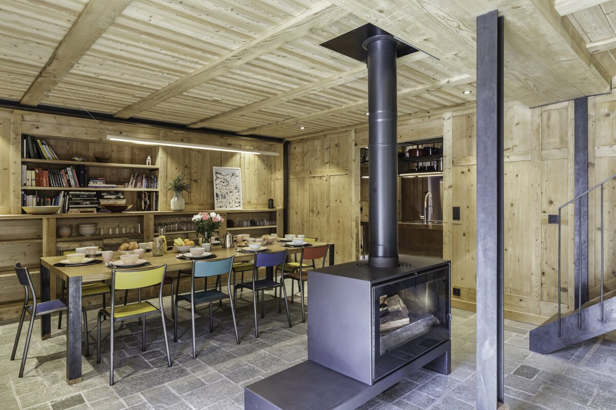 A dining room with a table and chairs and a fireplace