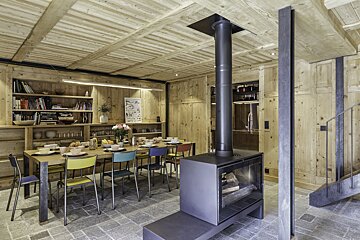 A dining room with a table and chairs and a fireplace