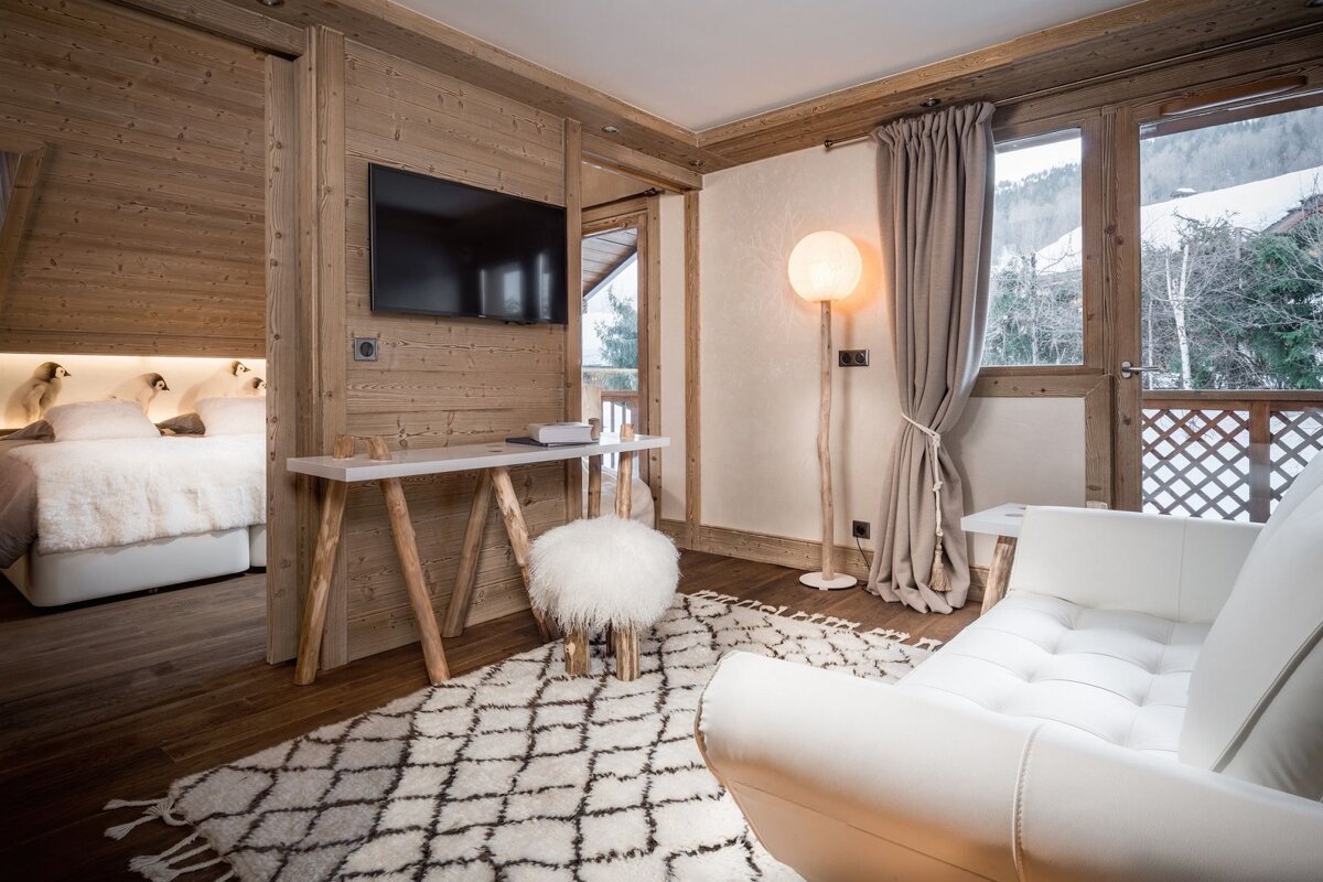A living room with a white chair and a white rug
