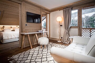 A living room with a white chair and a white rug