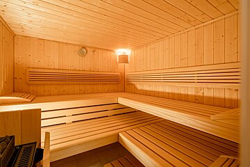 A wooden sauna with a light on the ceiling