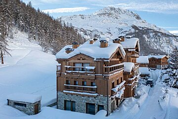 A snow covered building with a mountain in the background