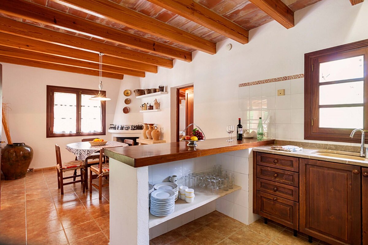 A kitchen with wooden cabinets and a bottle of wine on the counter