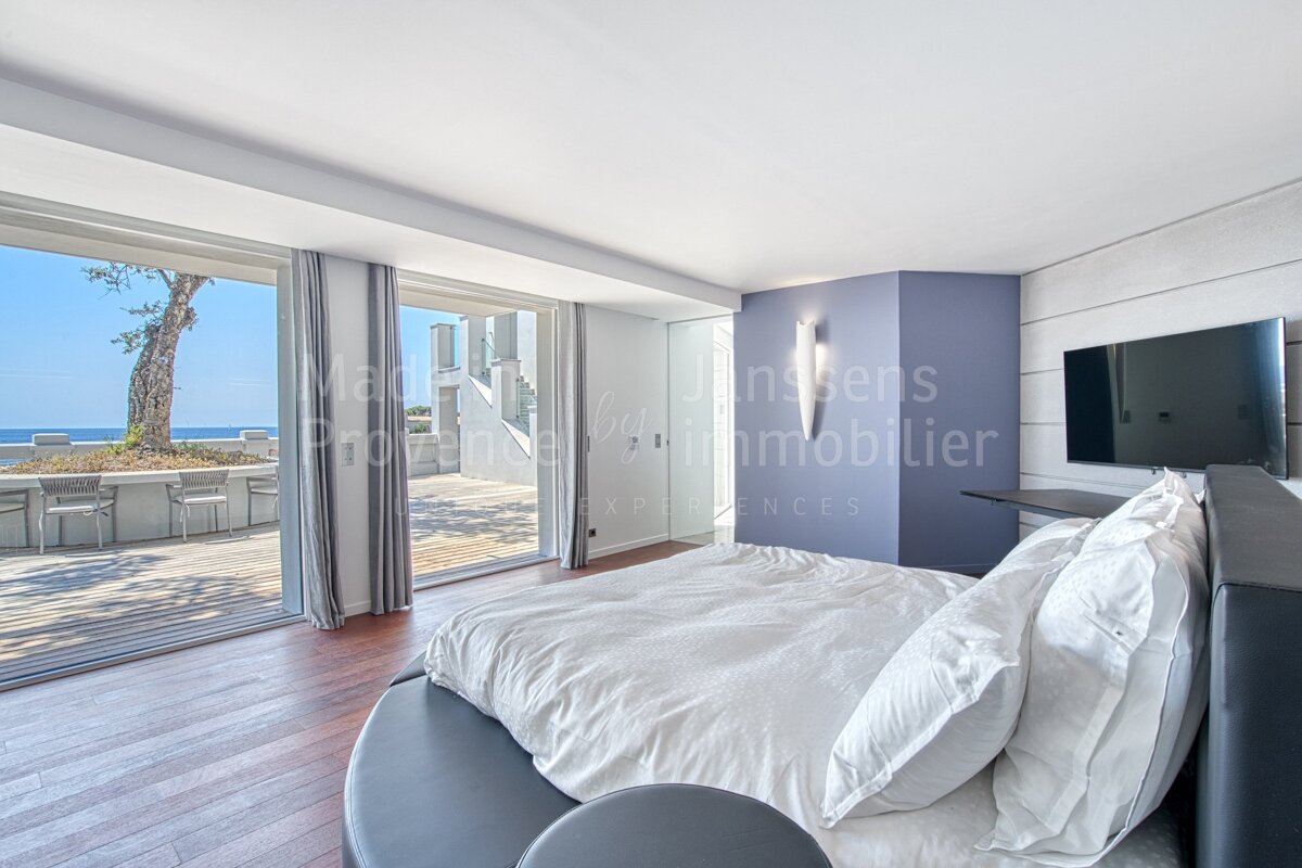 A bedroom with a large bed and a television that says immobilier