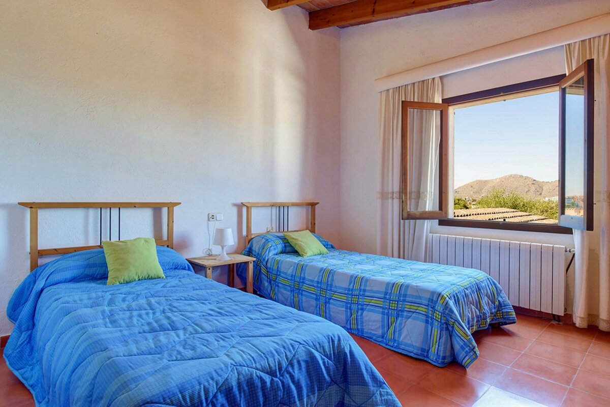 A bedroom with two twin beds and a window