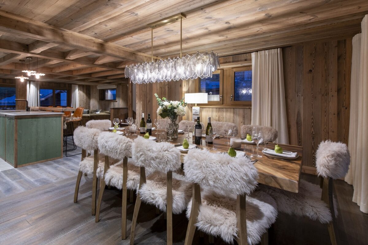 A dining room table with a bottle of wine on it