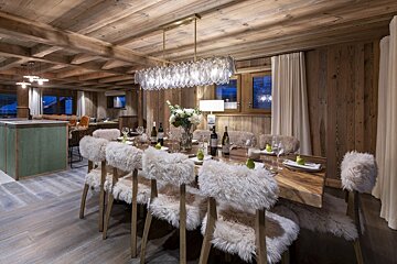 A dining room table with a bottle of wine on it