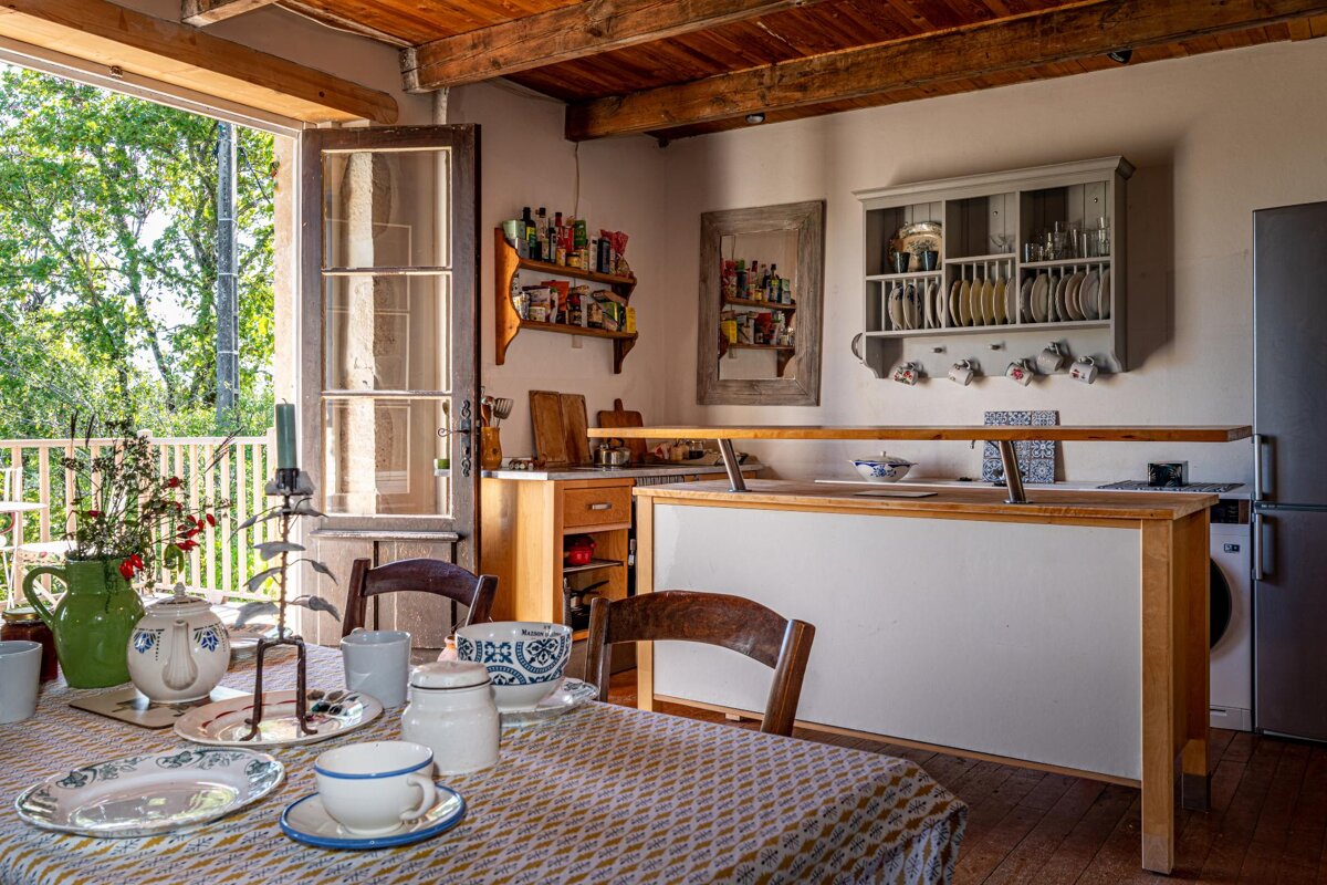 A kitchen with a table with plates and cups on it