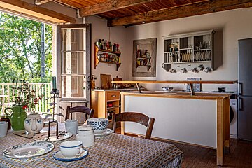A kitchen with a table with plates and cups on it