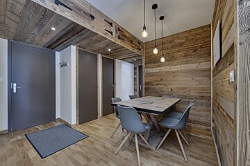 A dining room with a wooden table and chairs