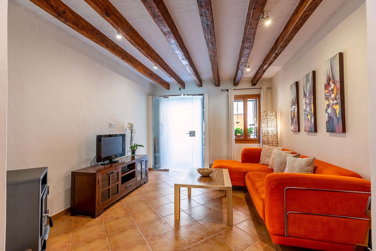 A living room with an orange couch and a flat screen tv