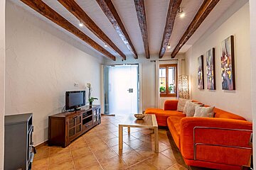 A living room with an orange couch and a flat screen tv
