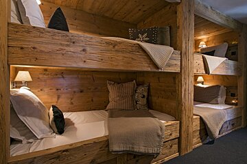 A wooden bunk bed with pillows and blankets on it