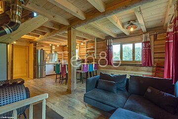 A living room in a log cabin with a couch and a sign that says t2n80