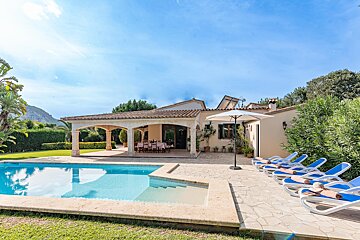 A house with a large swimming pool in front of it