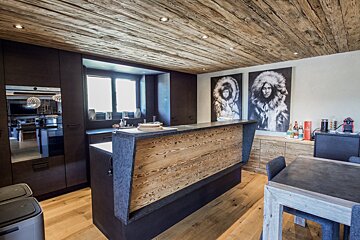 A kitchen with a wooden counter and two paintings on the wall