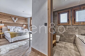 A bedroom with a deer head on the wall next to a bathroom