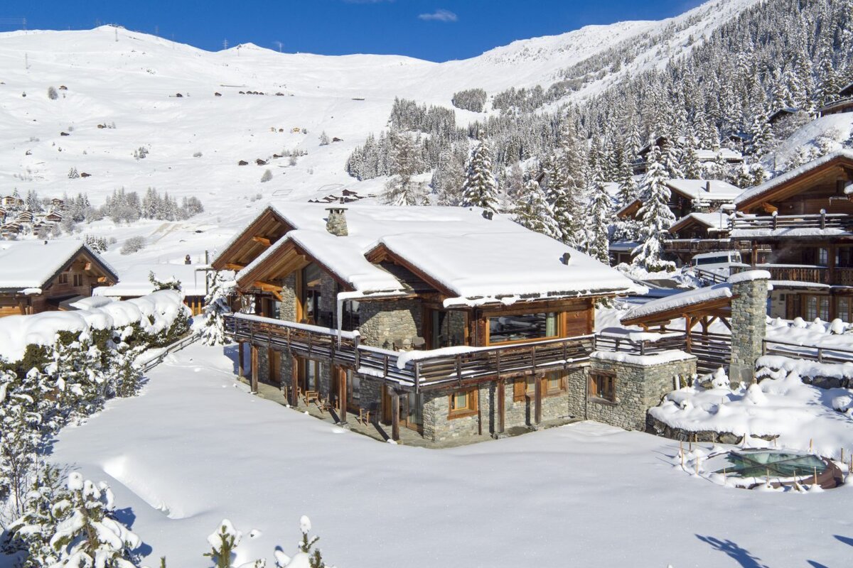 A snowy landscape with a large house in the foreground