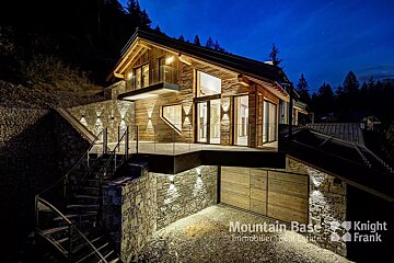A mountain base logo is on the side of a house