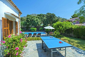 A ping pong table in front of a swimming pool
