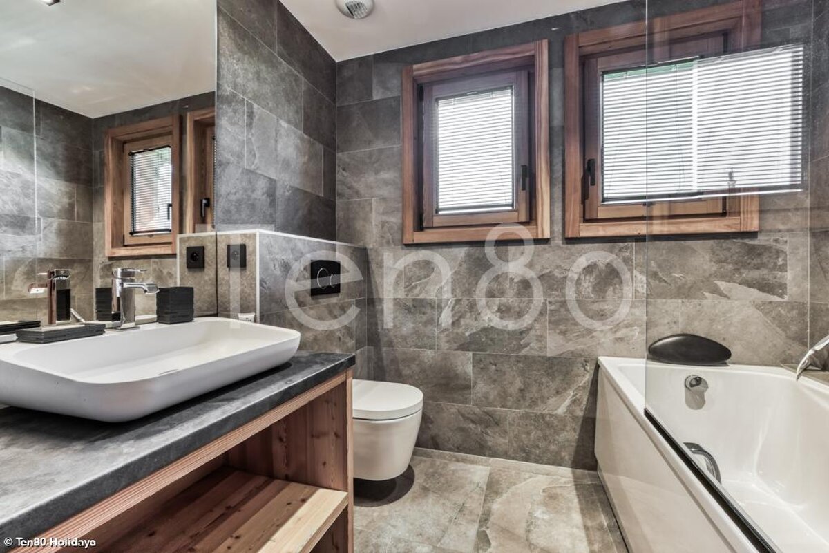 A bathroom with a sink a toilet and a bathtub with the word holidays on the wall