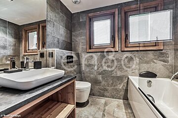 A bathroom with a sink a toilet and a bathtub with the word holidays on the wall