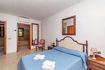 A bedroom with a blue bed and a mirror