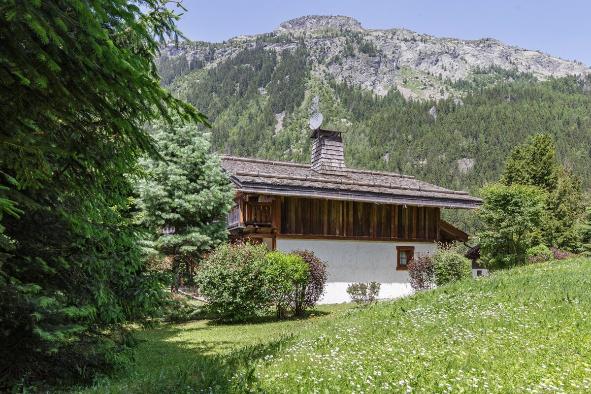 A house in the mountains with a satellite dish on the roof