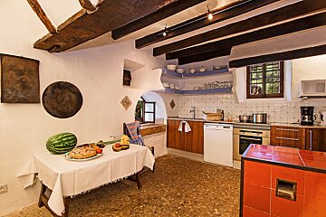 A kitchen with a watermelon and bread on a table