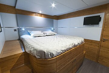 A bedroom with a large bed and a flat screen tv