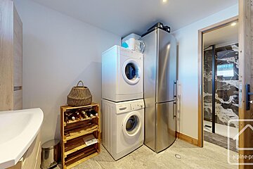 A washer and dryer are stacked on top of each other in a laundry room