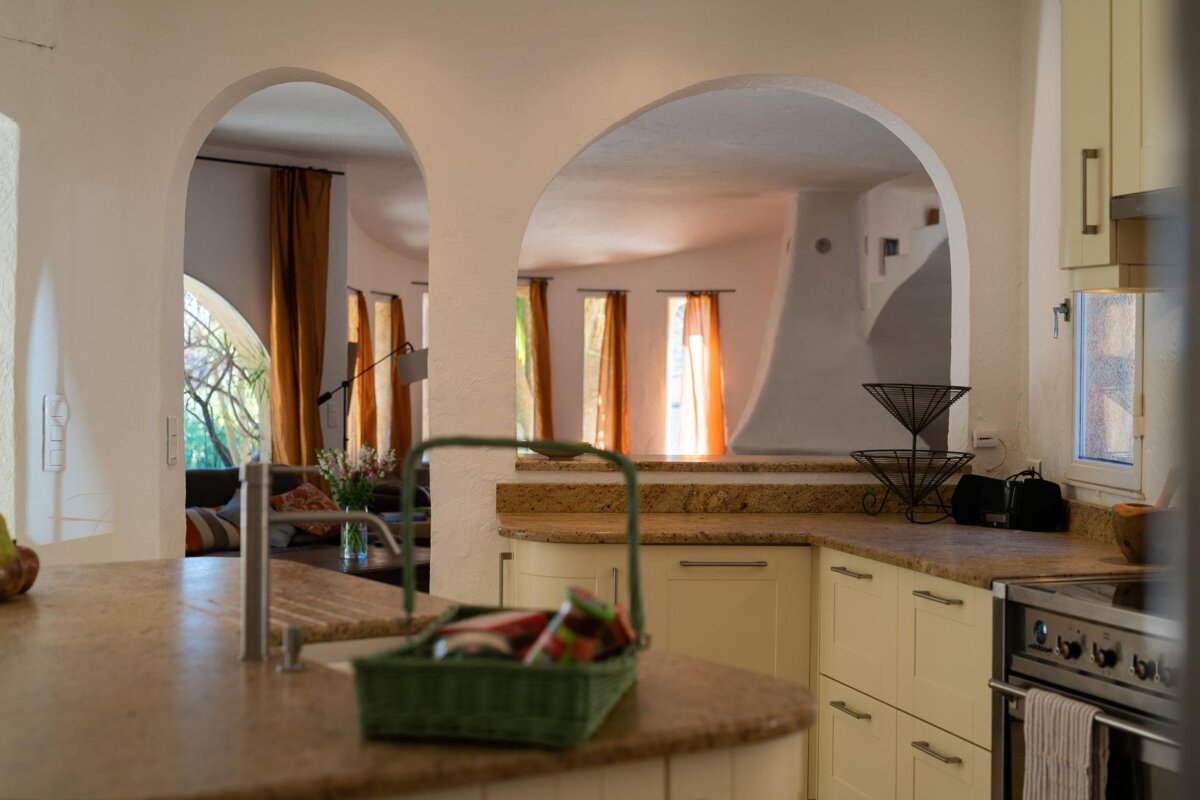 A kitchen with yellow cabinets and a green basket on the counter