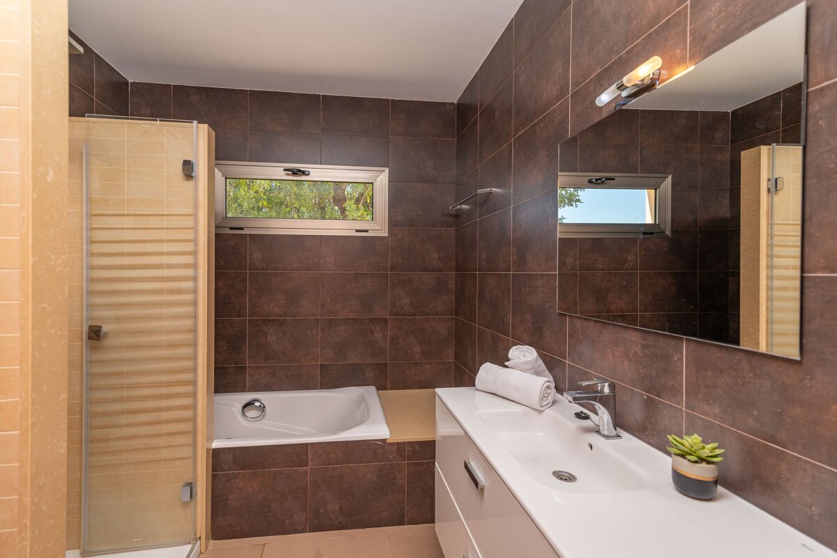 A bathroom with a tub and a sink and a mirror
