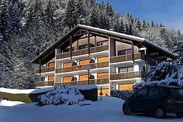 A car is parked in front of a snow covered building