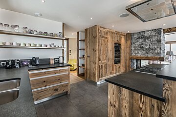 A kitchen with wooden cabinets and black counter tops