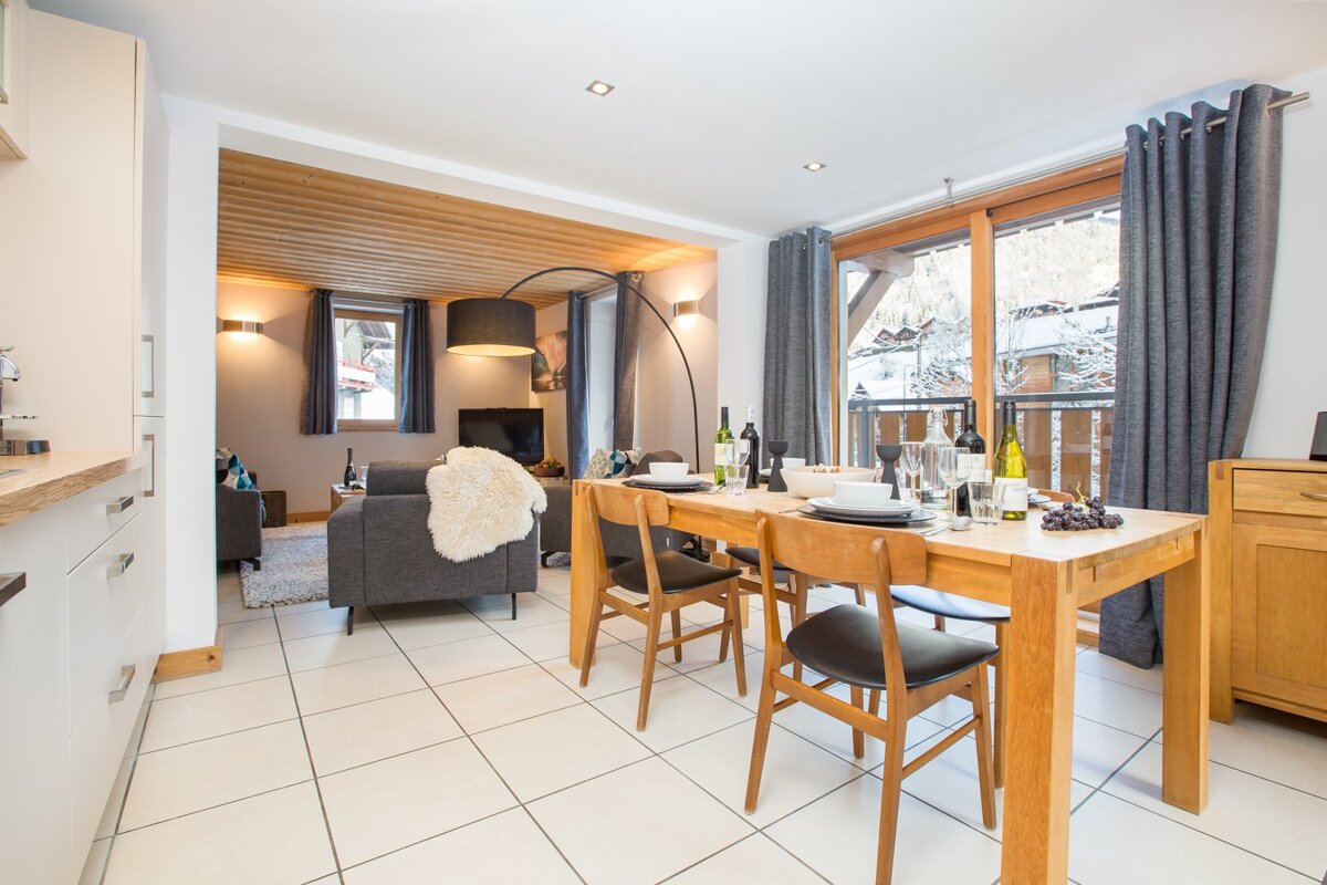 A dining room table with a bottle of wine on it
